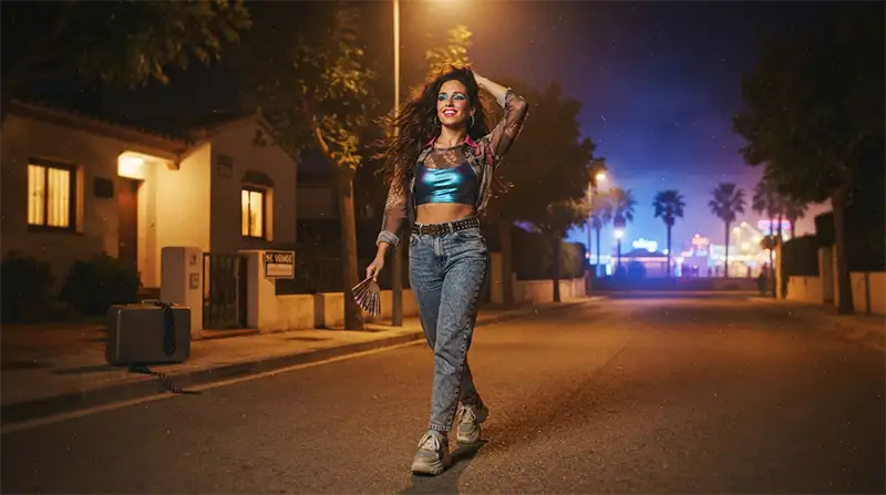 Mujer con estética dance de los noventa caminando hacia la noche como símbolo de libertad