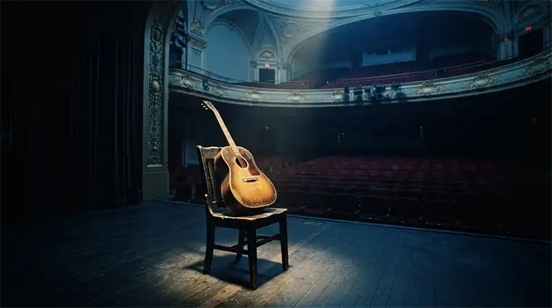 Guitarra solitaria sobre un escenario inspirada en el sentimiento de ausencia de Wish You Were Here.