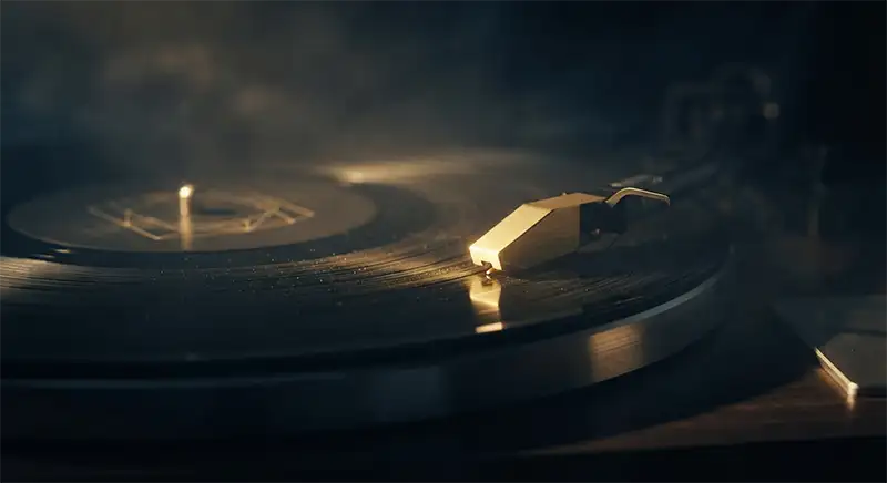 Aguja de tocadiscos sobre un vinilo en una habitación oscura y misteriosa.
